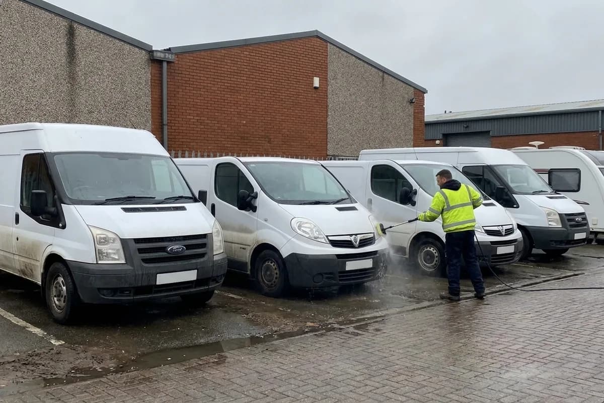 A fleet of vans being valeted on a depot yard