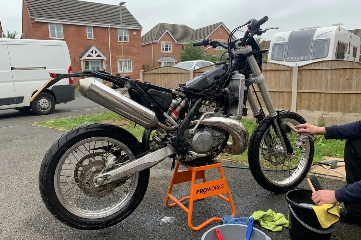 Motorbike being cleaned and detailed by hand on a stand